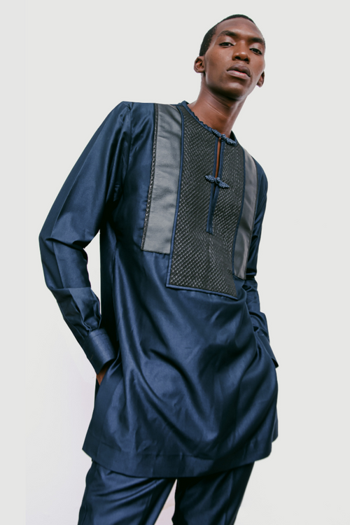 Man wearing a blue traditional outfit with a plain background