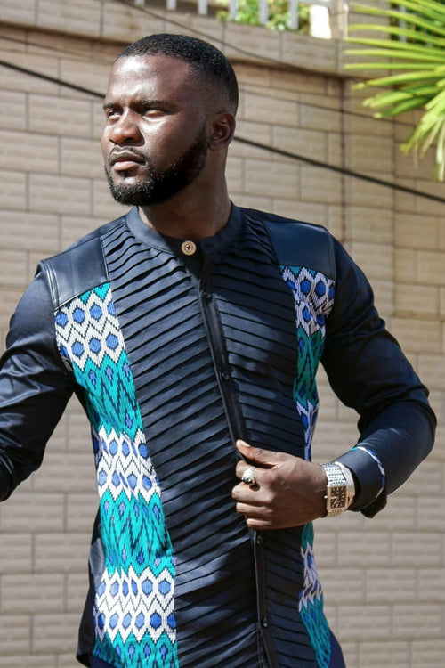 A man wearing a black long-sleeve shirt with geometric pattern in blue and green, featuring a round neckline.